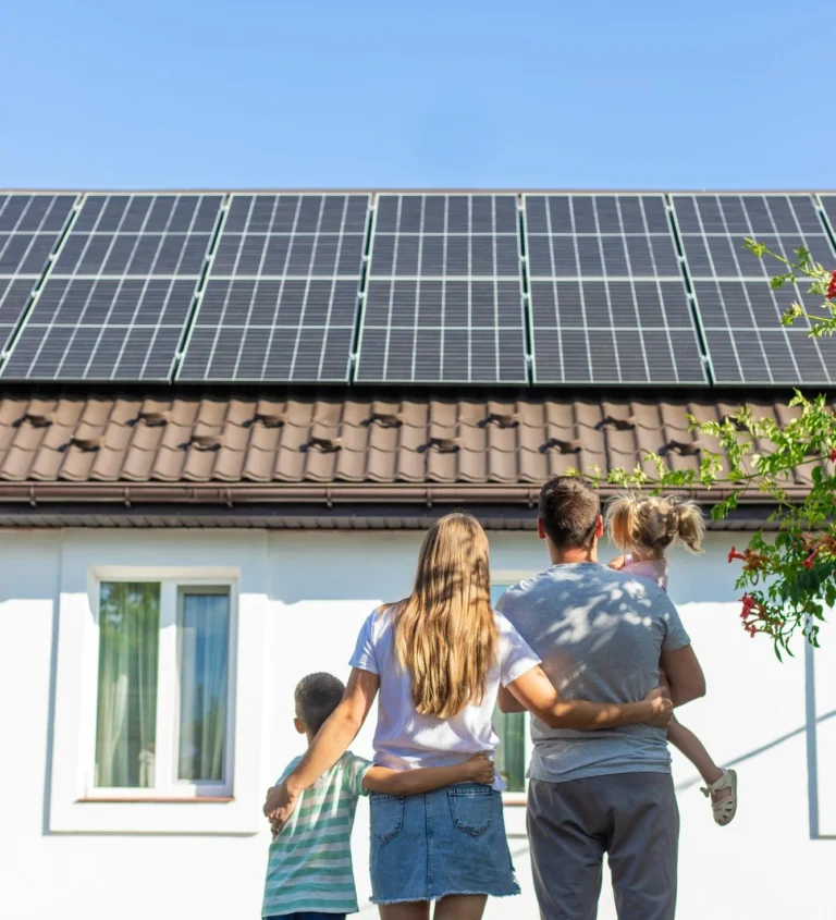 Family standing in front of their home installed with solar panels